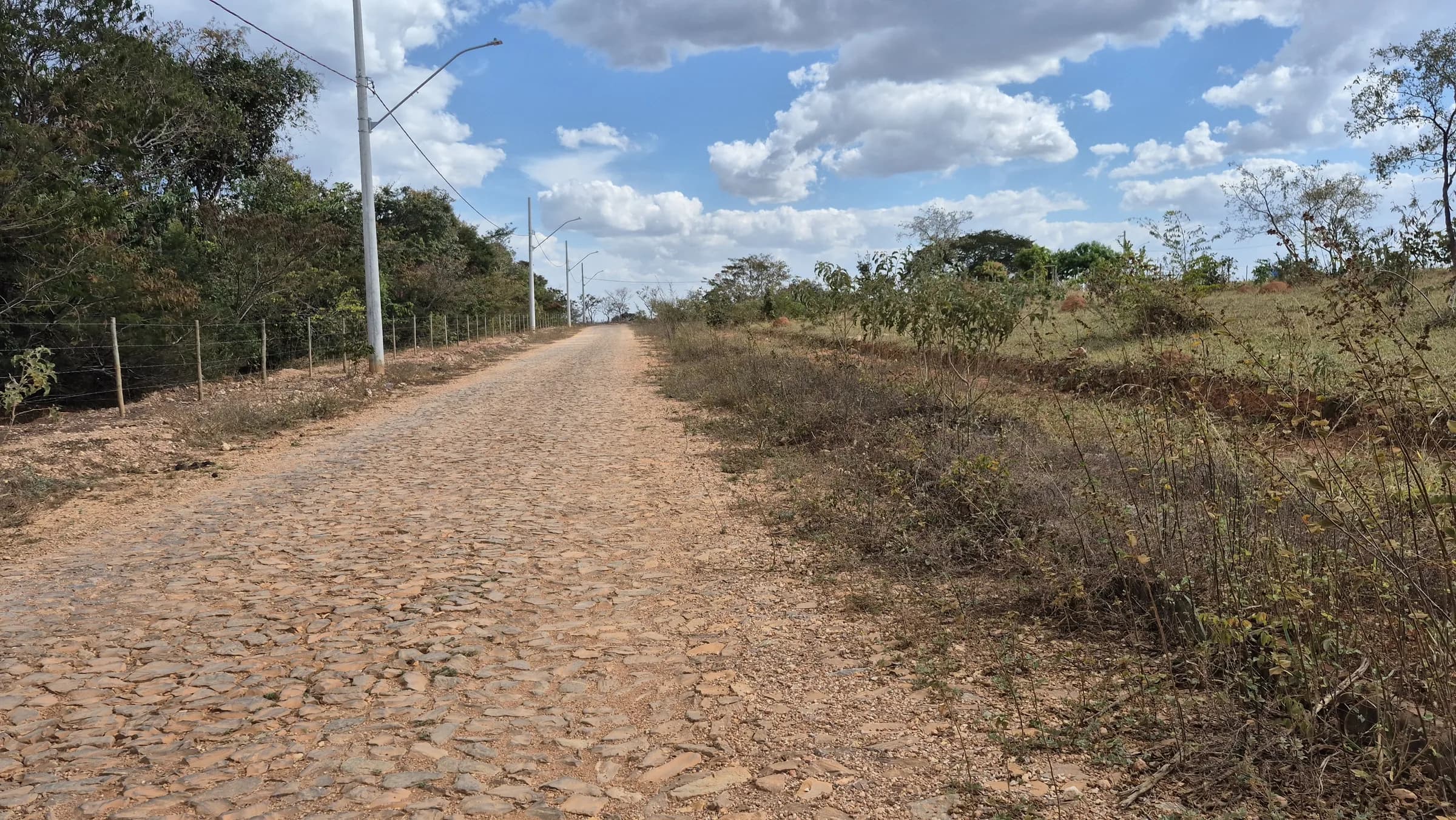 Rua com calçamento de pedra e postes de iluminação pública no Mirante da Serra